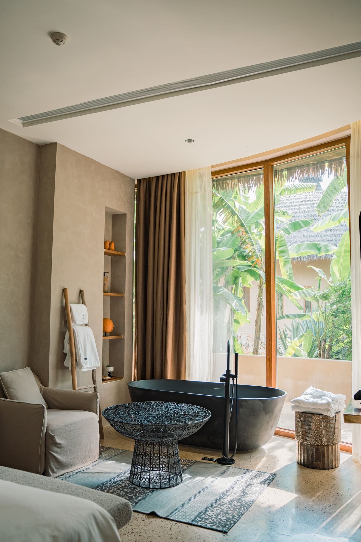 A treatment suite with a stone soaking tub and a full-height window
