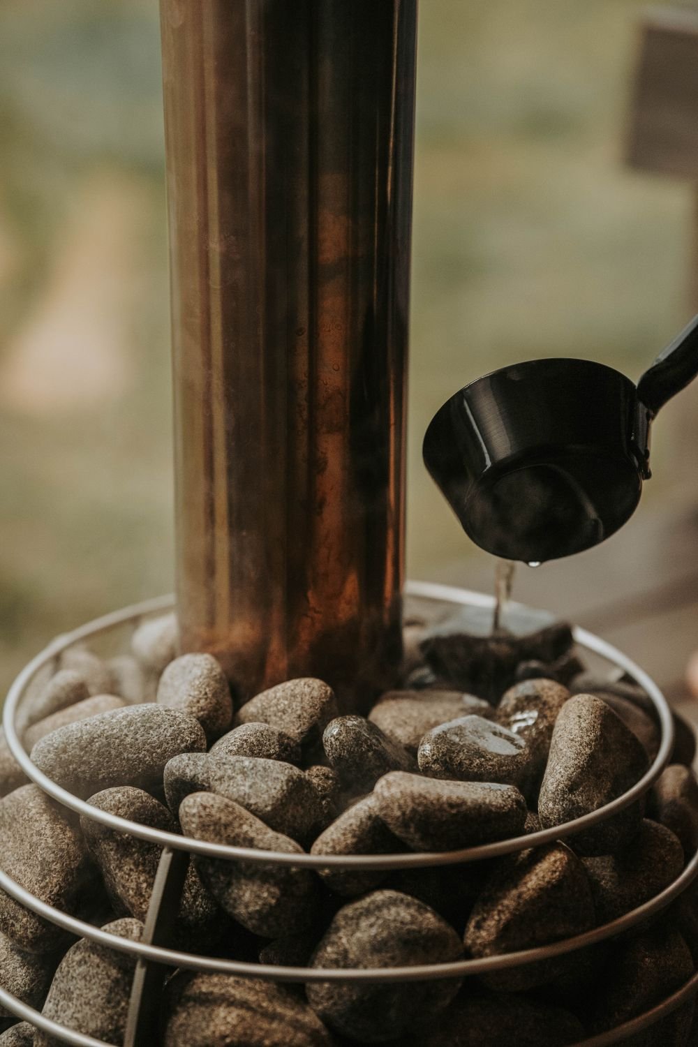 The sauna heater, river stones and a black ladle
